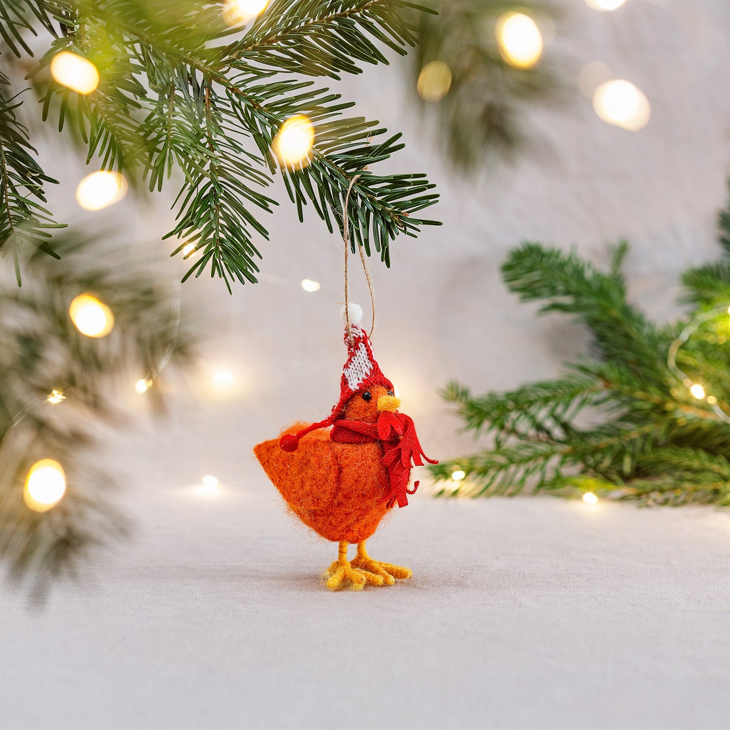 Festive felt chicken decoration wearing red woolly hat – hanging on Christmas tree