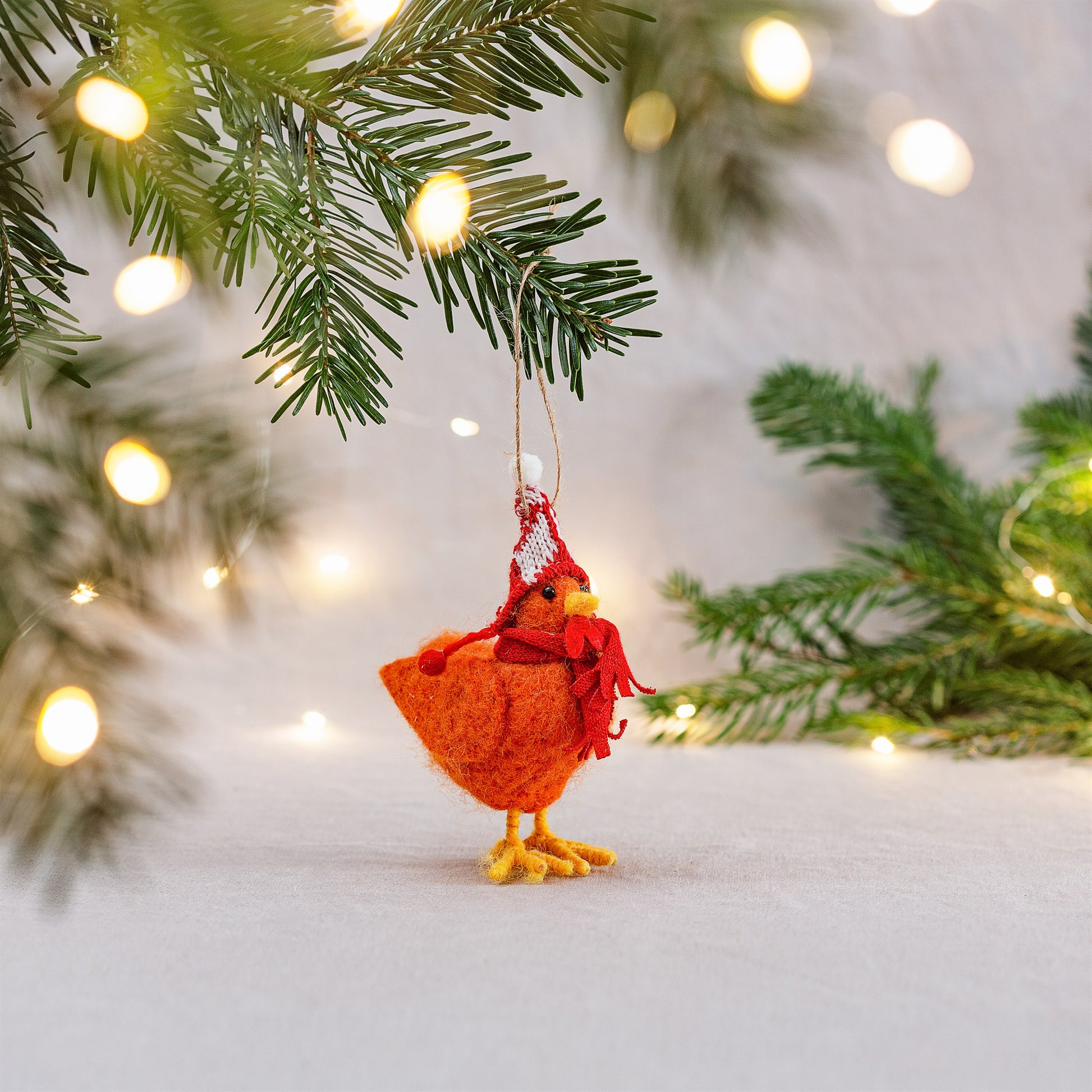 Festive felt chicken decoration wearing red woolly hat – hanging on Christmas tree