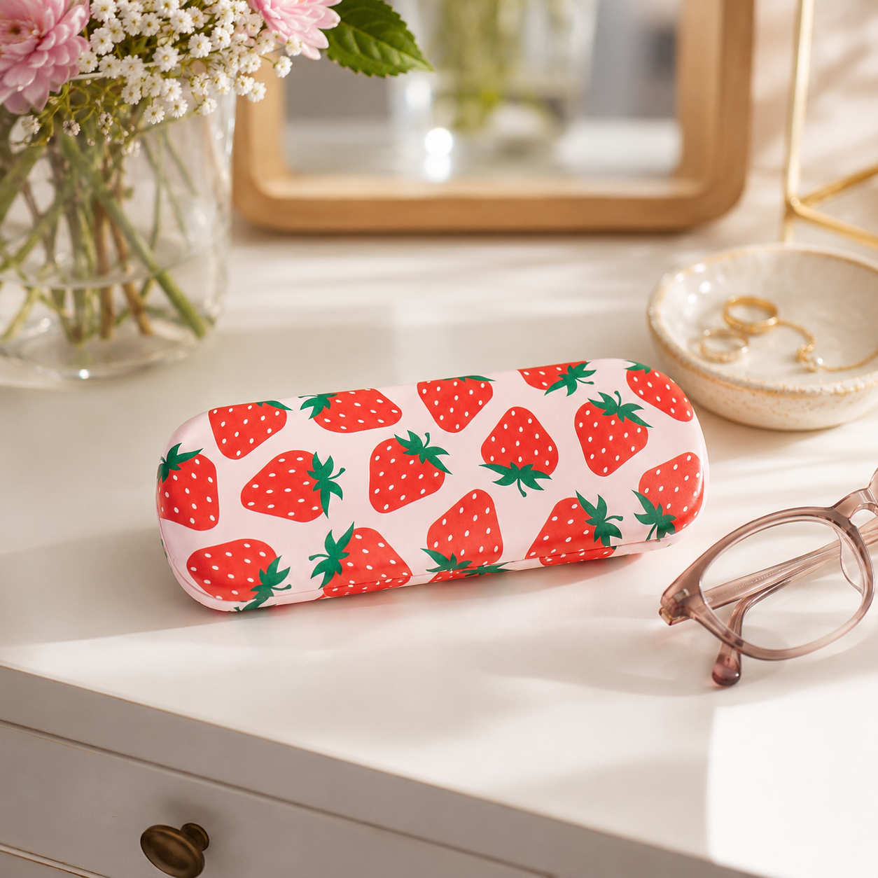 Sass & Belle Strawberry Glasses Case lifestyle image beside everyday handbag accessories